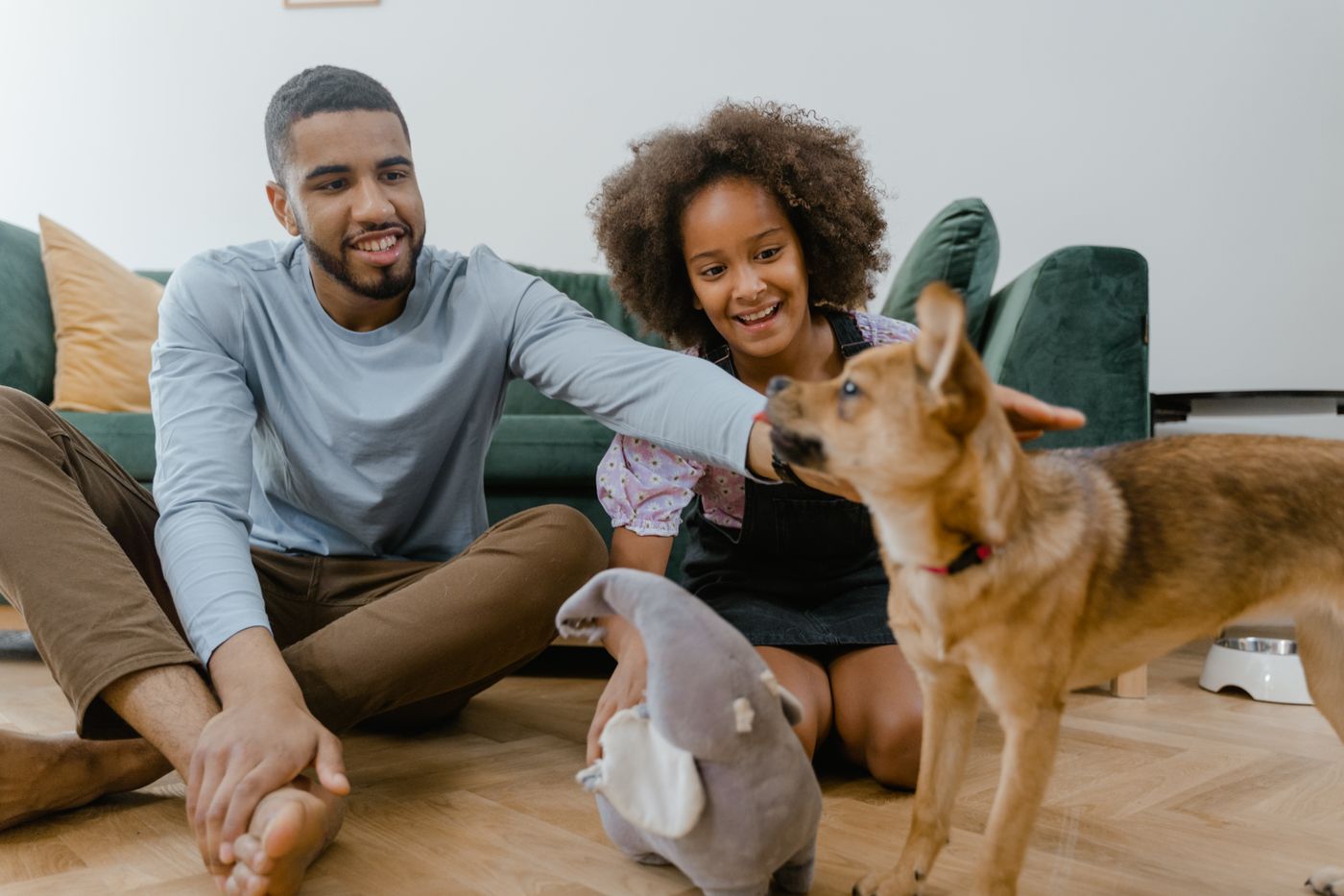Family members seated at floor level with their dog.
